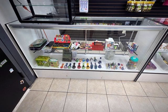 The accessories counter — glass, grinders, trays and scales under lit glass.