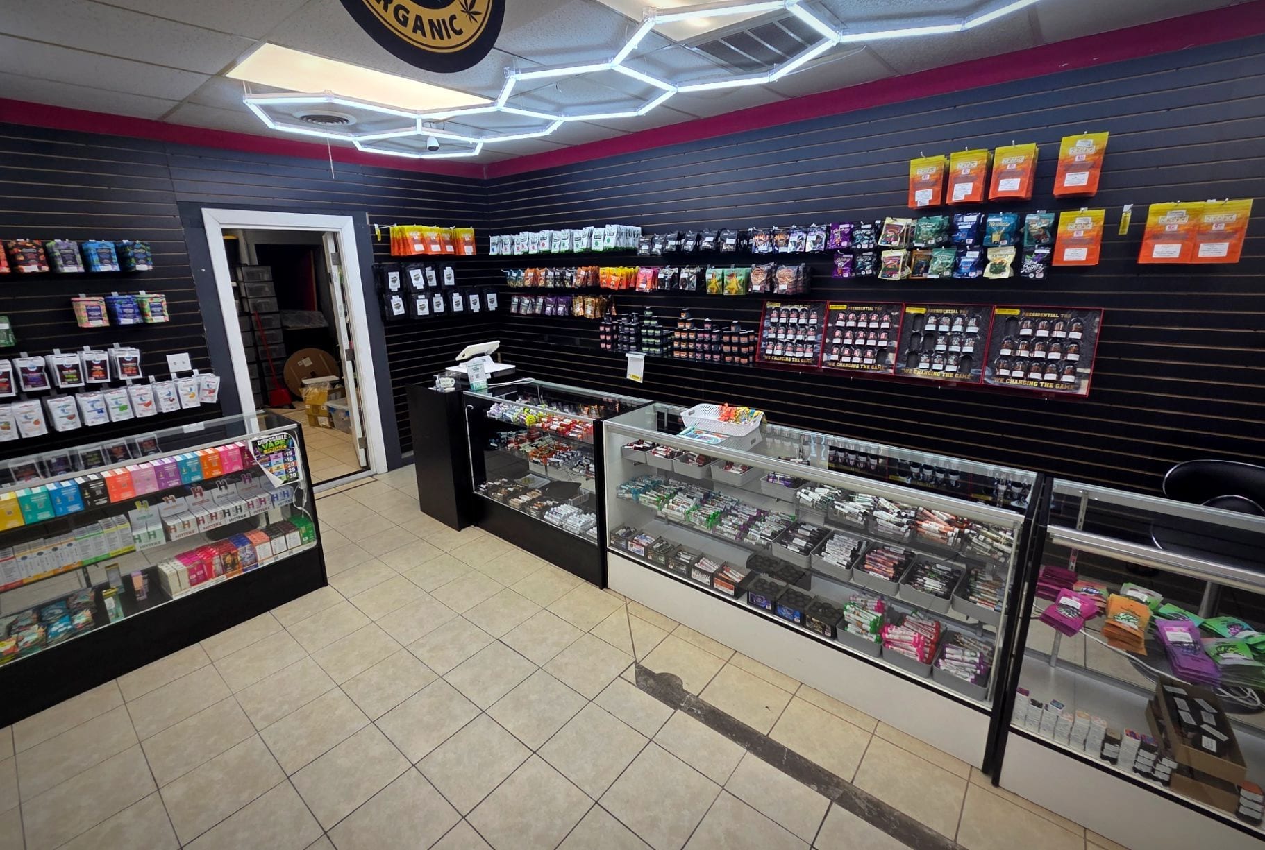 The main sales floor, with hexagonal ceiling lights over black slatwall and glass counters.