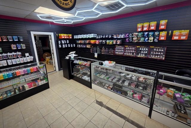 The main sales floor, with hexagonal ceiling lights over black slatwall and glass counters.